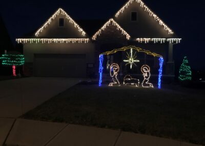 residential holiday lighting with yard art and religious display