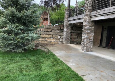 concrete patio with boulder retaining wall