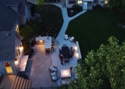 concrete patio with fire pit and retaining walls at night