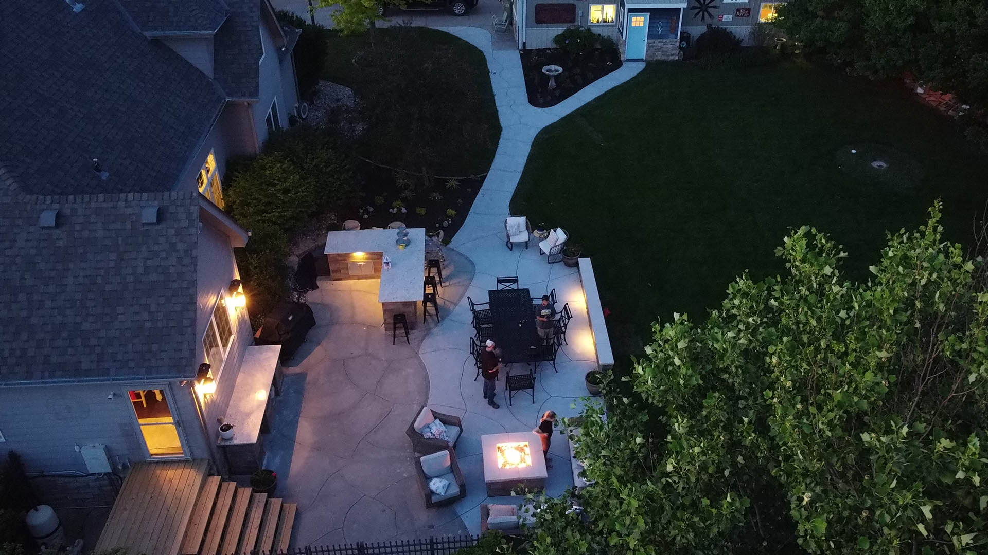 concrete patio with fire pit and retaining walls at night